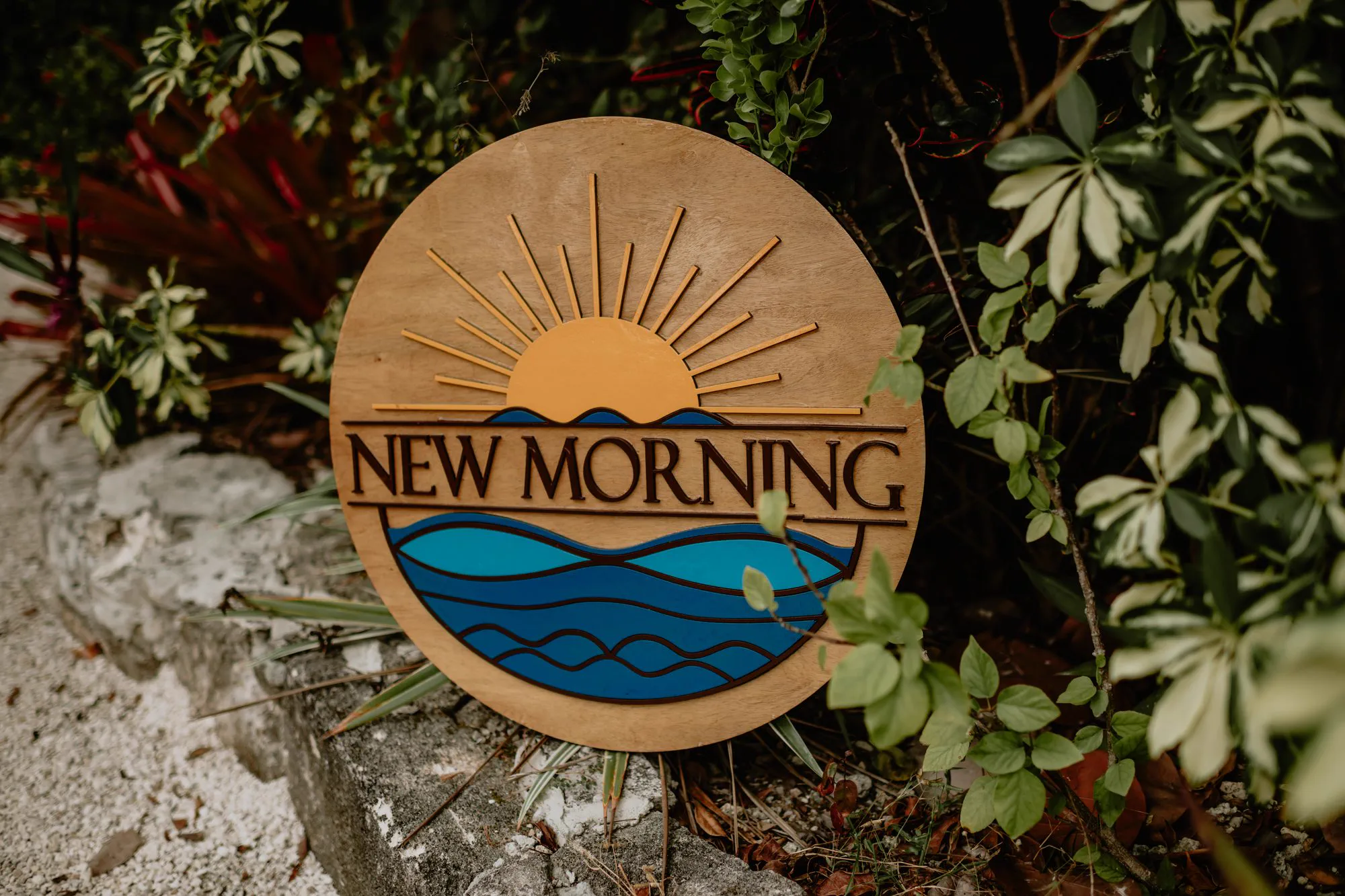 The carved New Morning sign set among sea grape and palm at the North End of Elbow Cay.