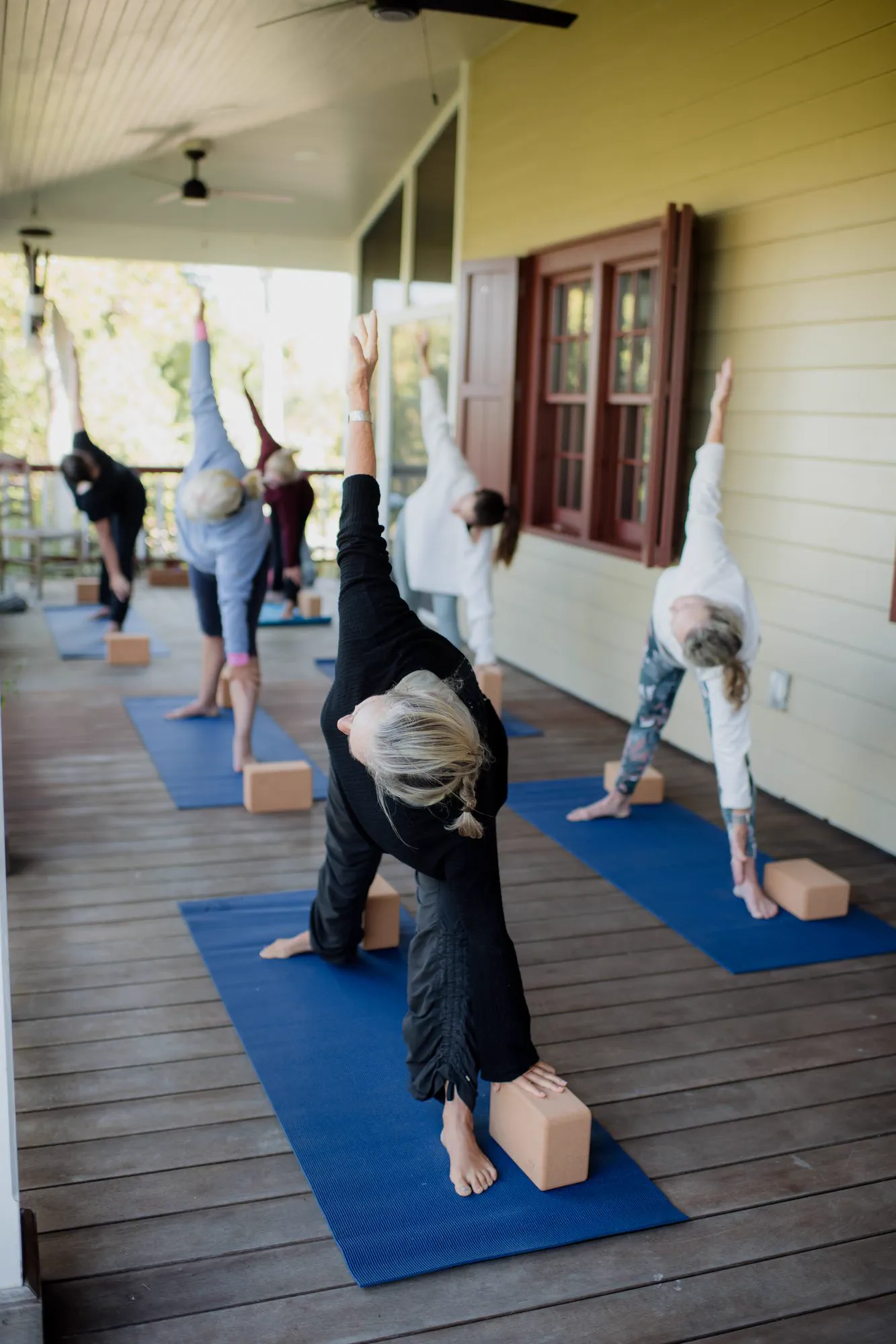 A guest moving through a supported inversion during morning yoga practice.